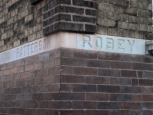 Stone lintel carved with the words Patterson Robey, set into a brick facade.